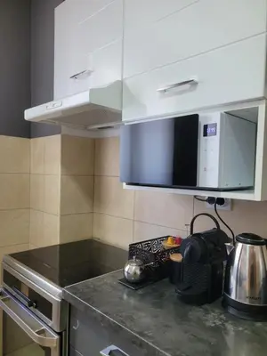 a kitchen with white cabinets and a counter top at Apartman Riva Parking Garaža in Kraljevo