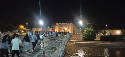 a group of people walking over a bridge at night at Lux apartment 12 center, free parking in Niš