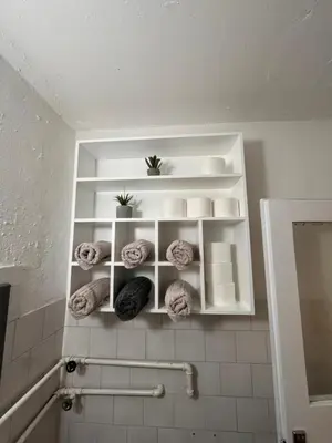 a bathroom with white shelves and towels on the wall at Devetka in Pirot