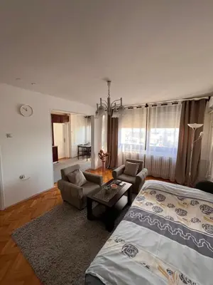 a bedroom with a bed and a couch and a table at Devetka in Pirot