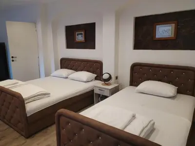 a bedroom with two beds and a mirror at UB Prenociste in Vranjska Banja