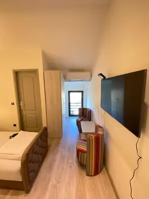 a room with a bed and a tv and a chair at UB Prenociste in Vranjska Banja