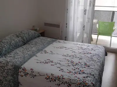 a bedroom with a bed with a floral bedspread on it at Green Apartman in Paraćin