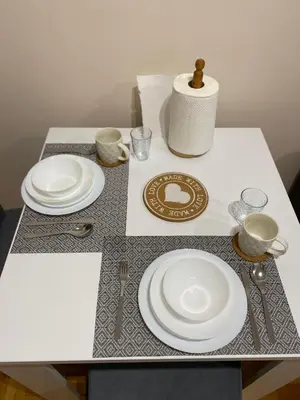 a table with plates and utensils on it at Apartman Breza 3 in Kruševac