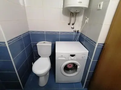a small bathroom with a toilet and a washing machine at Apartman Breza 3 in Kruševac