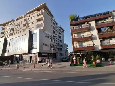 people walking down a street in front of buildings at Apartman Breza 3 in Kruševac