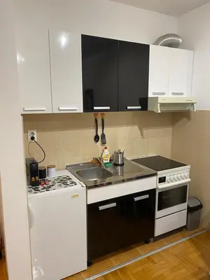 a kitchen with black and white cabinets and a stove at Apartman Breza 3 in Kruševac