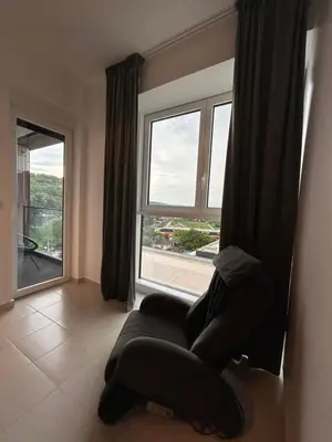 a room with a chair in front of a window at Matic Apartmani 4 in Trnava