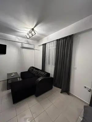 a living room with a black couch and a window at Matic Apartmani 4 in Trnava