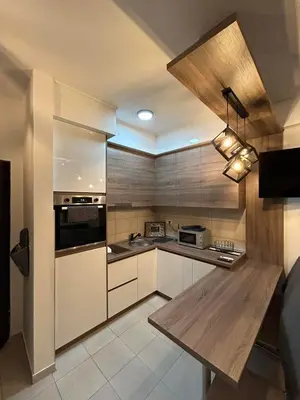 a kitchen with white cabinets and a wooden counter top at Matic Apartmani 4 in Trnava