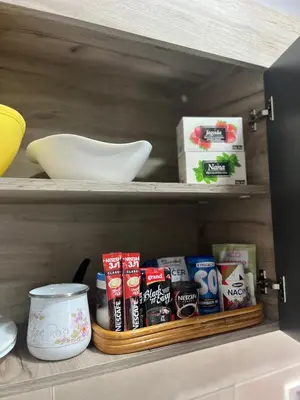 a shelf in a kitchen with various food items at R Lux Apartman Jagodina Akva Park in Jagodina