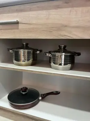 two pots and pans on a shelf in a kitchen at R Lux Apartman Jagodina Akva Park in Jagodina