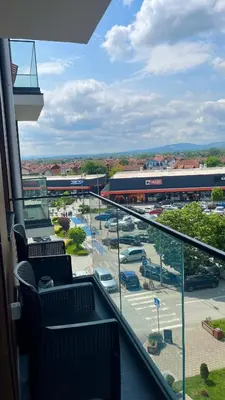 a balcony with chairs and a view of a parking lot at R Lux Apartman Jagodina Akva Park in Jagodina
