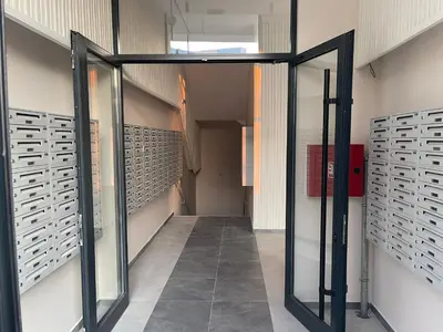 a hallway with glass doors in a building at R Lux Apartman Jagodina Akva Park in Jagodina