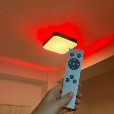 a person holding a wii remote control with a light on the ceiling at R Lux Apartman Jagodina Akva Park in Jagodina
