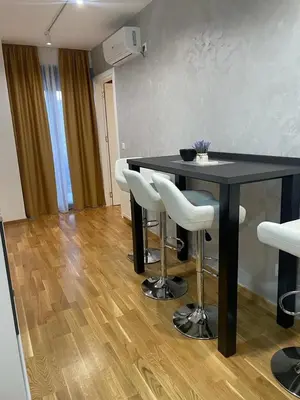 a dining room with a black table and white chairs at luxury Pool Apartment Jagodina in Jagodina