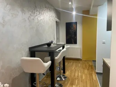 a dining room with a table and two white chairs at luxury Pool Apartment Jagodina in Jagodina