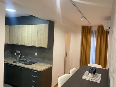 a kitchen with a sink and a table with chairs at luxury Pool Apartment Jagodina in Jagodina