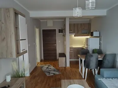 a living room with a blue couch and a kitchen at SPA 25 in Vrnjačka Banja