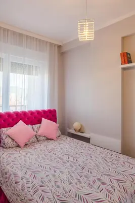 a bedroom with a large bed with pink pillows at SPA 25 in Vrnjačka Banja