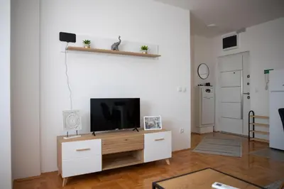 a living room with a flat screen tv on a cabinet at City Center Condo Vranje in Vranje
