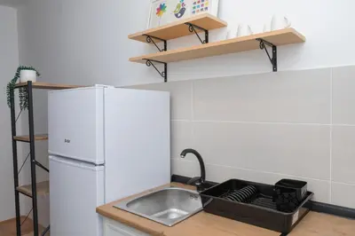 a kitchen with a sink and a white refrigerator at City Center Condo Vranje in Vranje
