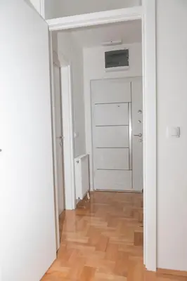 an empty room with a door and a wooden floor at City Center Condo Vranje in Vranje