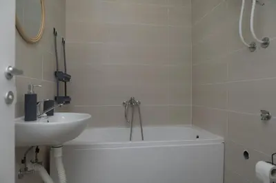 a bathroom with a bath tub and a sink at City Center Condo Vranje in Vranje