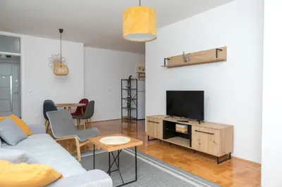 a living room with a couch and a tv at City Center Condo Vranje in Vranje