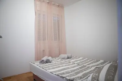 a bed with towels on it with a window at City Center Condo Vranje in Vranje