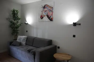 a living room with a couch and a painting of a zebra at Apartman Mist - Bela Reka Kopaonik in Brzeće