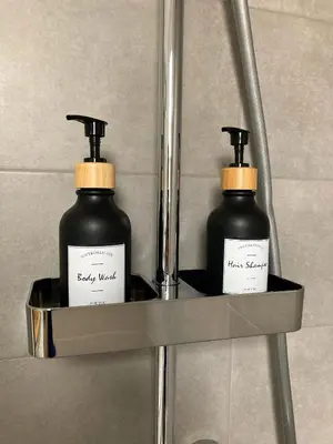 two bottles of soap on a shelf in a bathroom at Agro Lux Apartment - Milenović in Soko Banja
