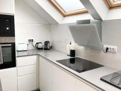 a kitchen with white cabinets and a stove top oven at Agro Lux Apartment - Milenović in Soko Banja