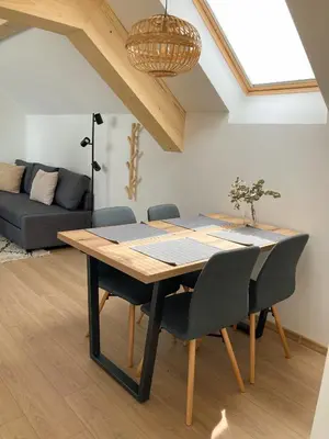 a dining room table and chairs in a living room at Agro Lux Apartment - Milenović in Soko Banja