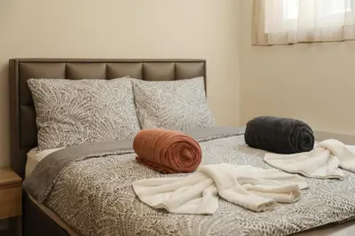 a bed with two blankets and pillows on it at GOLDEN VIEW Sokobanja in Soko Banja