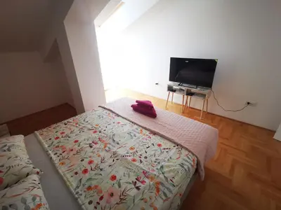 a bedroom with a bed and a flat screen tv at Riviera Apartments in Niš