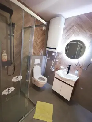 a bathroom with a shower and a toilet and a sink at Riviera Apartments in Niš