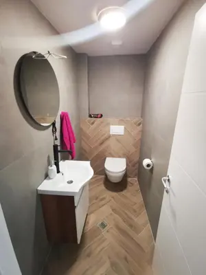 a bathroom with a toilet and a sink and a mirror at Riviera Apartments in Niš