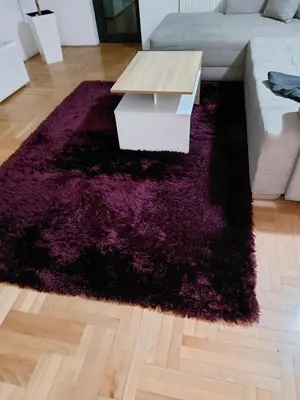 a living room with a purple rug and a coffee table at Riviera Apartments in Niš