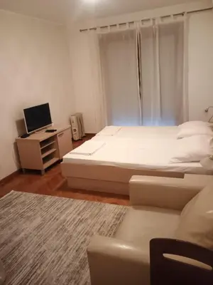 a bedroom with a bed and a desk with a computer at Apartman Sneznik in Vrnjačka Banja