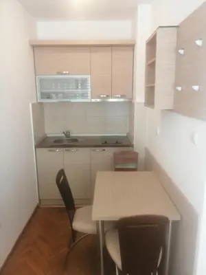 a kitchen with a table and chairs and a microwave at Apartman Sneznik in Vrnjačka Banja