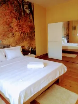 a bedroom with a white bed with a painting on the wall at Timočko gnezdo in Zaječar
