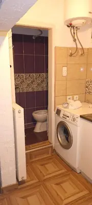 a small bathroom with a toilet and a washing machine at Timočko gnezdo in Zaječar
