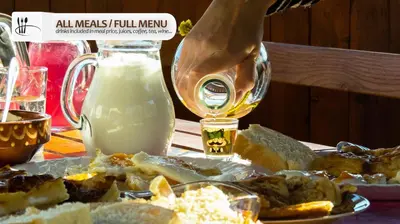 a table with a plate of food and a bottle of milk at Eco Farm Milanovic in Despotovac