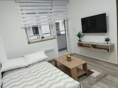 a living room with a couch and a flat screen tv at Garden Hill Apartment in Jagodina