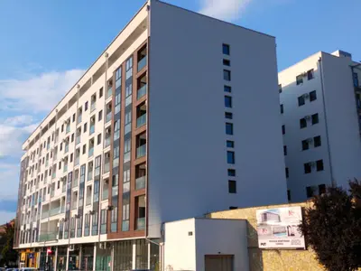 a large white building in front of a building at Garden Hill Apartment in Jagodina