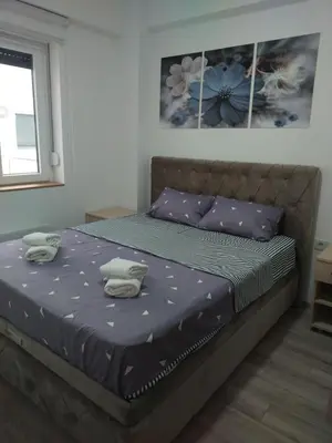 a bedroom with a bed with two towels on it at Garden Hill Apartment in Jagodina