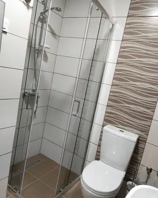 a bathroom with a toilet and a glass shower at Garden Hill Apartment in Jagodina