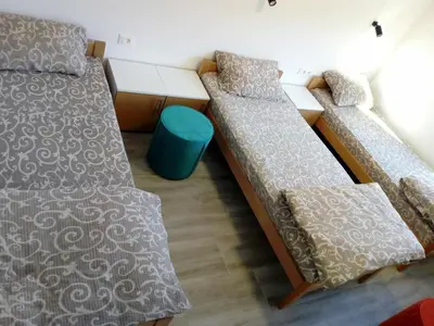 a room with two beds and a blue stool at STD Cvetković in Crni Vrh
