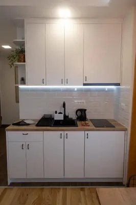 a kitchen with white cabinets and a sink at Lux Apartman Sunce in Jagodina